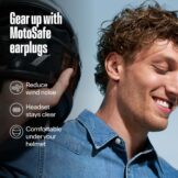 Motorcycle rider wearing Alpine MotoSafe Tour earplugs for wind noise reduction under a helmet.